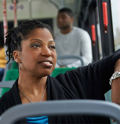 A woman riding the bus and looking out of the window