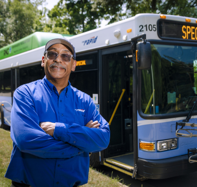 Bus Driver standing in front of a bus